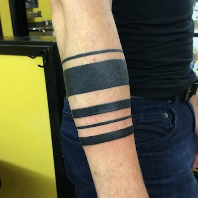 Vemos un antebrazo de hombre tatuado con un brazalete tribal