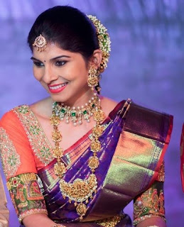 Woman wearing orange blouse with violet saree