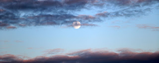 Moon behind wisps of cloud