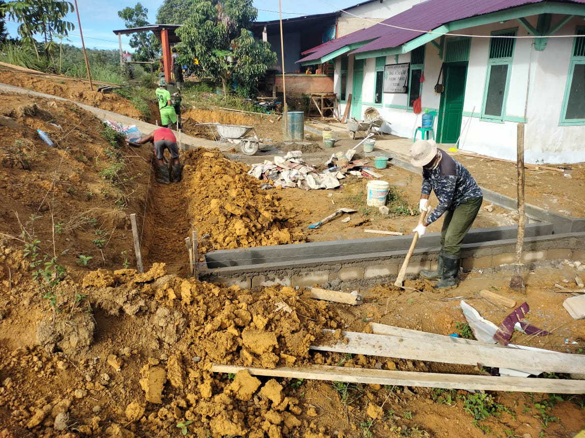 Pembuatan Parit Kecil Di Sekeliling Bangunan Pustu Oleh Anggota Satgas TMMD Ke-111 Kodim 1202/Skw