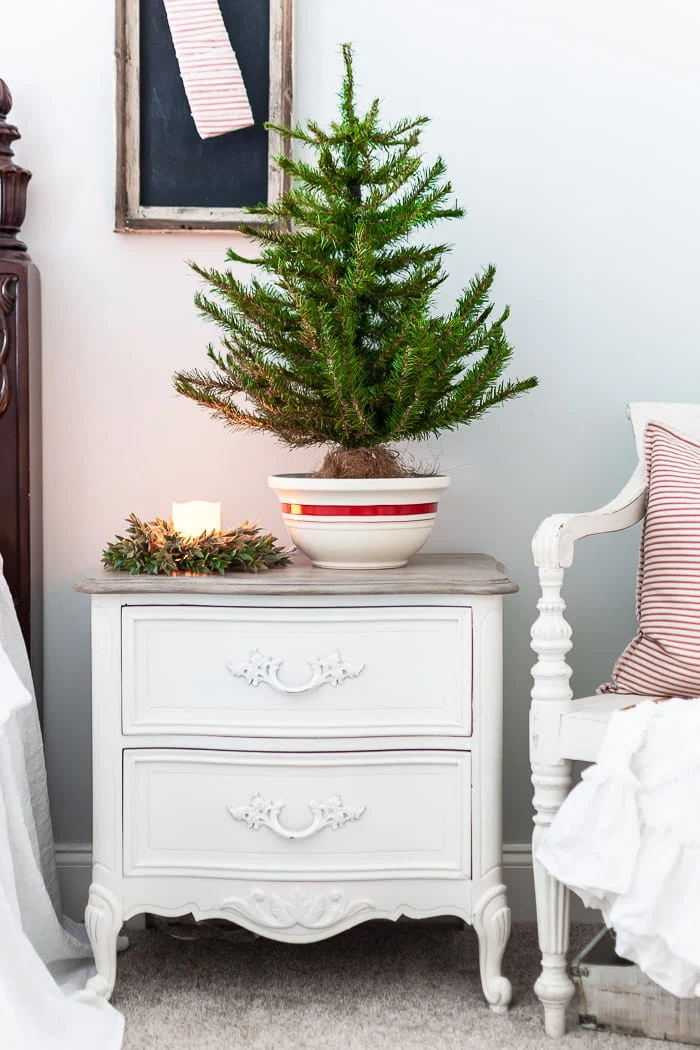 white nightstand, red striped bowl, mini tree