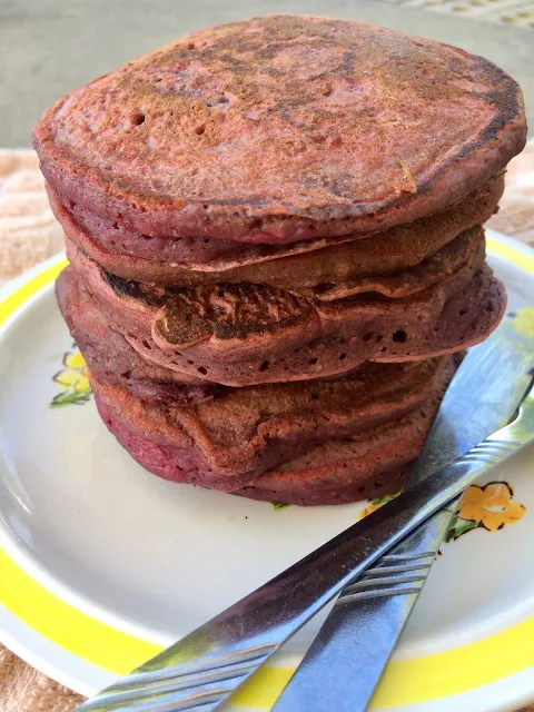 Stack of beet pancakes on a serving plate.