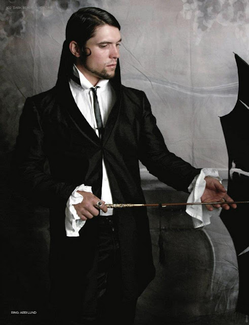 Man in steampunk clothing. Black jacket, trousers, white ruffle shirt with black tie. His hair is slicked back and he carries a black umbrella. For gothic victorian fashion, steamgoth cosplay, halloween costume or neo-victorian steampunk clothes.