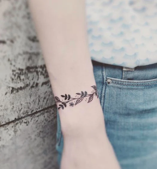vemos la fotografia de una chica elegante con un tatuaje sencillo pero muy bonito