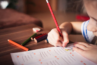 Image of a girl writing with pencil