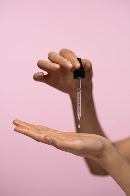 Person holding serum dropper photo by Ron Lach