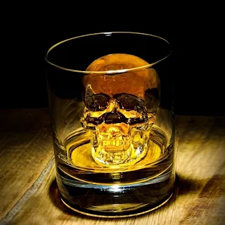 vaso con bebida e hielo calavera