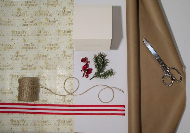 Gift wrap theme with tree sprigs, striped ribbon, berries, twine, gift box and brown paper