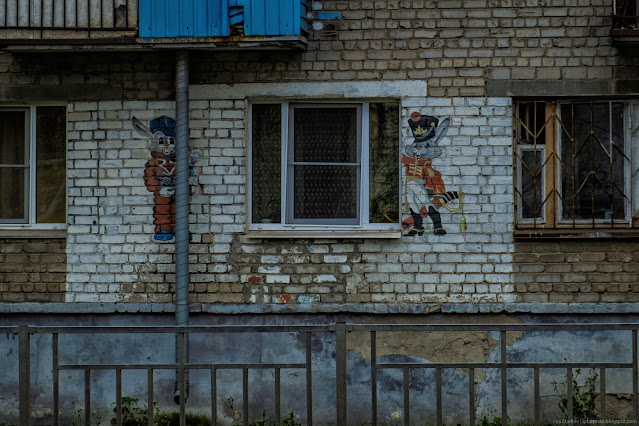 Рисунок сказочных персонажей у окна многоквартирного дома