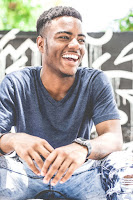 A laughing young man in jeans and t-shirt