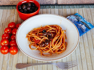 foto di spaghetti alla marinara con olive nere, pomodorini ed acciughe