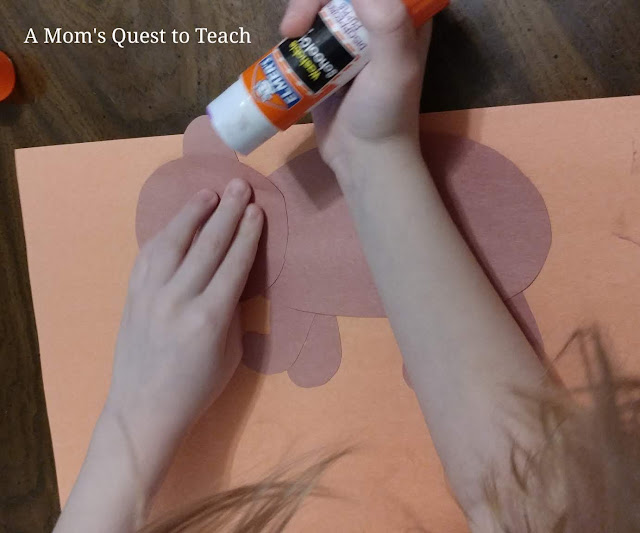 gluing ear onto brown construction paper bear