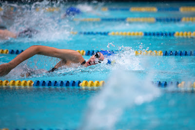 Picture of a happy woman burning calories whilst swimming in her lane in the pool