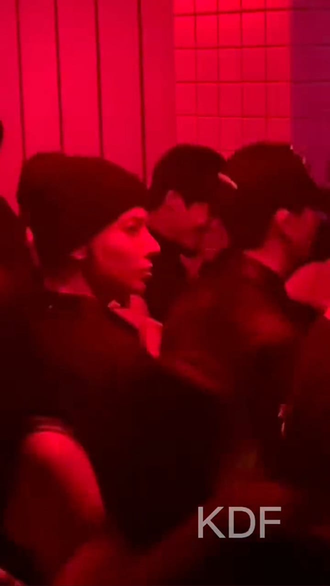 Imagen de Taehyun dentro del club nocturno, bailando y divirtiéndose con amigos.
