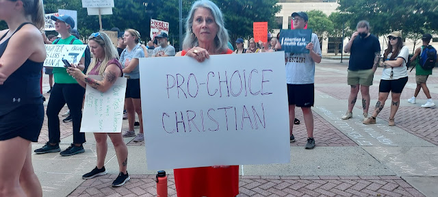 Pro Choice Christian - lady holding a sign at protest march