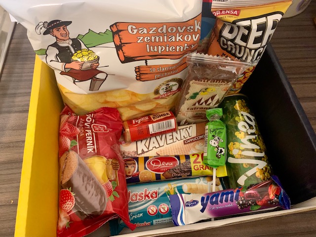 Box of Slovakian snacks, including chocolate bars, crisps and can drink