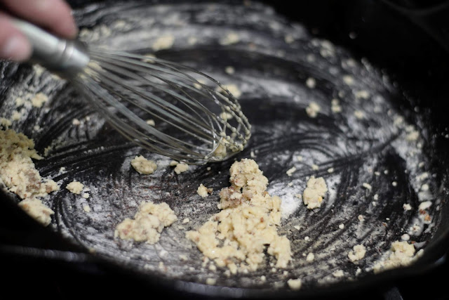 The flour being whisked in the cast iron skillet.