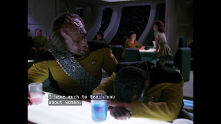 Worf leans over Geordi at the bar of Ten-Forward, saying "I have much to teach you about women."