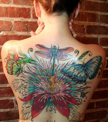 Big, beautiful, and colorful dragonfly, butterfly, and flower tattoo on the 