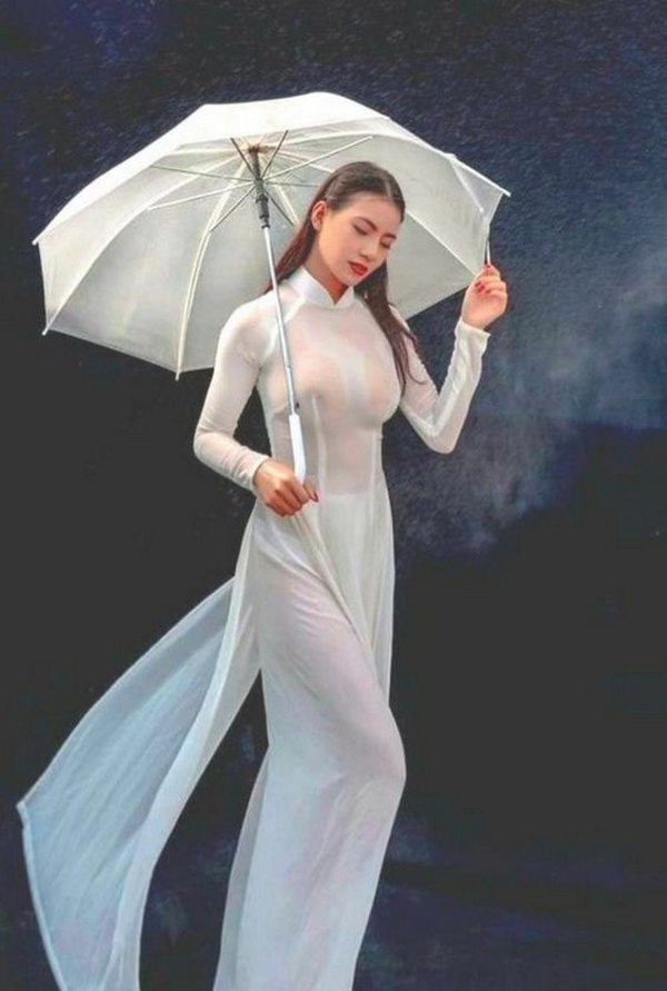 Thiếu nữ áo dài trắng che dù ướt mưa
