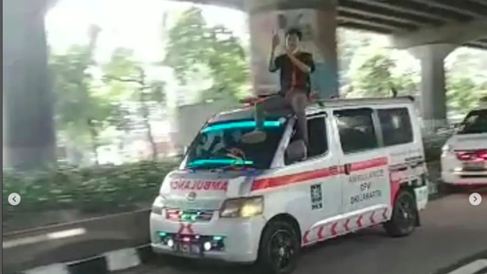 VIRAL! Aksi Pria Duduk di Atas Ambulans Berlogo PKB di Jaktim