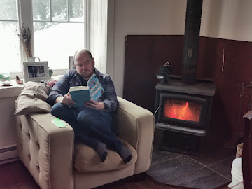 Reading a book by the wood burner