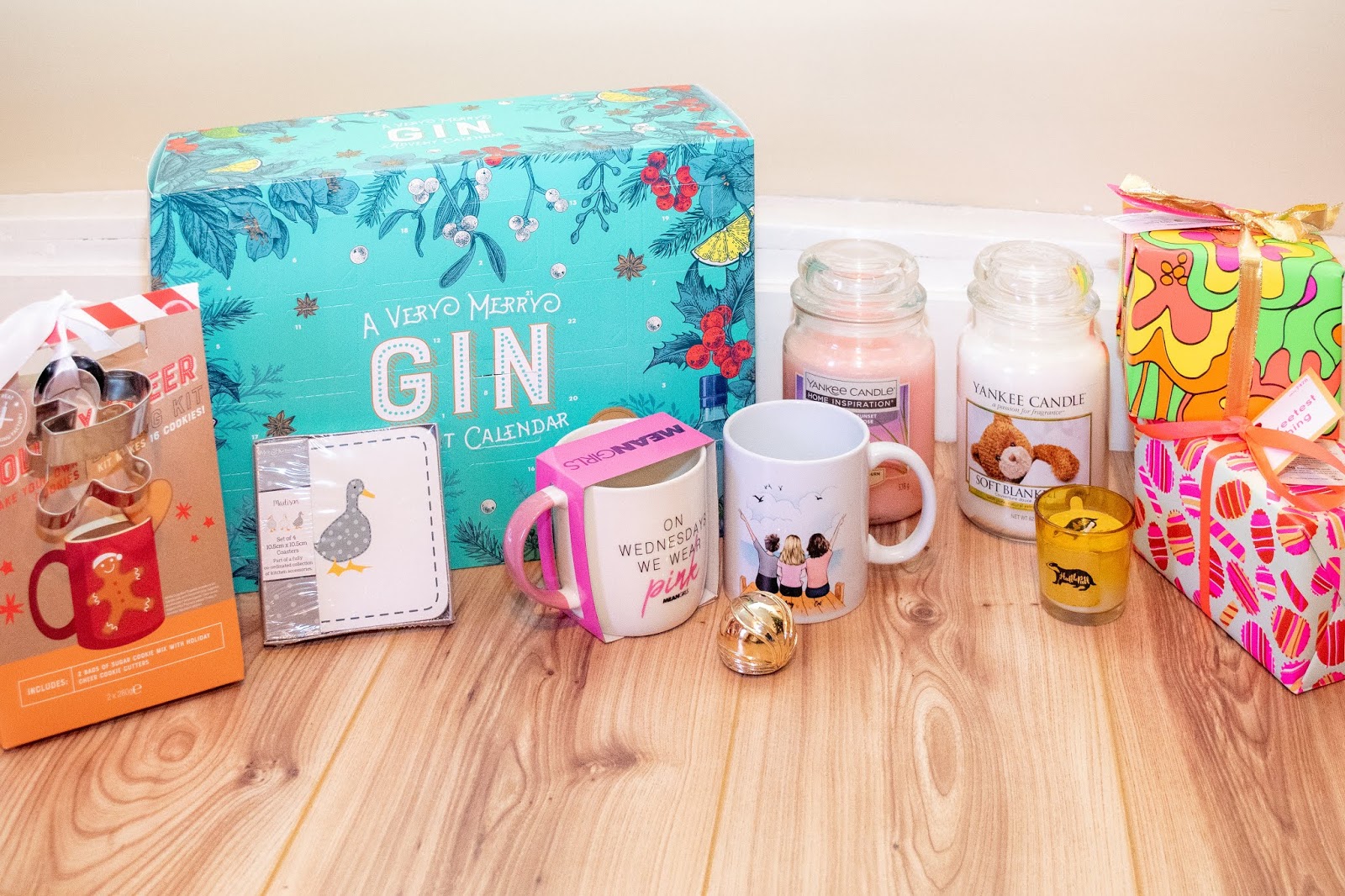 Food and home related gifts together: gin advent calendar, duck coasters, two mugs, a gingerbread baking kit, candles, lush sets.