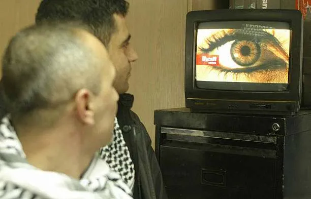 Lebanese men watch the newly launched US-funded Arabic-language television network Alhurra in Beirut on February 16, 2004. Photo by Ramzi Haidar/AFP