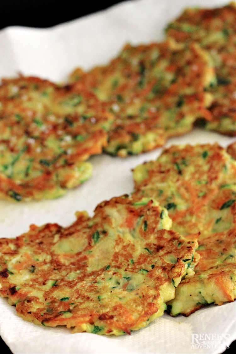 Cooked zucchini carrot fritters on a paper towel lined plate ready to serve