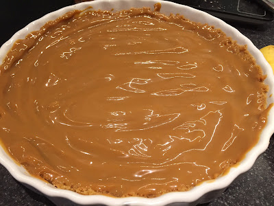 Caramel layer of the Banoffee Pie in a white dish