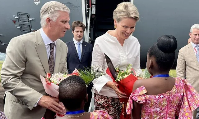 Queen Mathilde wore a white linen belted blouse and wide leg printed linen trousers from Natan. Dr. Denis Mukwege