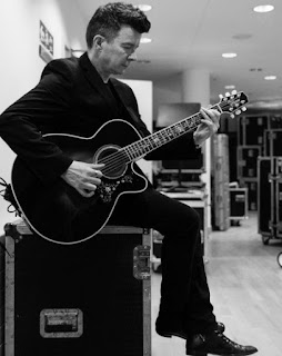 Picture of Rick Astley playing guitar