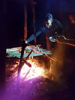 Fire highlighting the face of Moses as he tends the barbeque