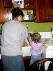 Elaine washing dishes with mommy