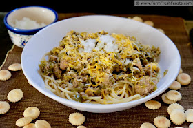 photo of a bowl of chorizo and green tomato chili atop spaghetti noodles