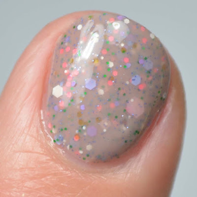 nude nail polish with 60's inspired glitter mix swatch