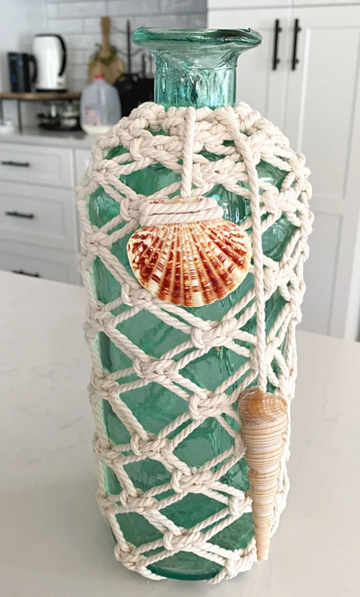 shells on strings hanging from side of vase