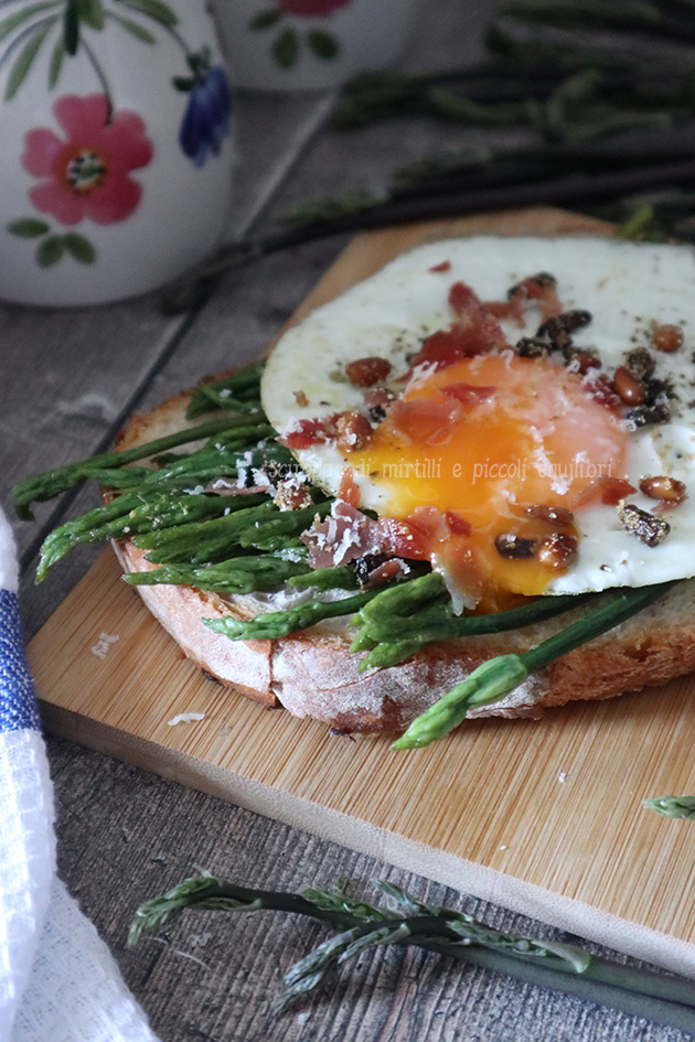 Bruschetta con asparagi selvatici, uovo, briciole di prosciutto crudo e pinoli croccanti