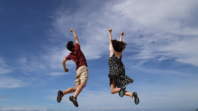 two people jumping high up