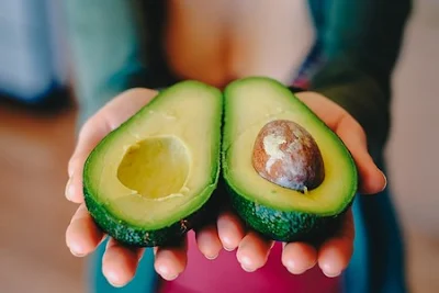 holding an avocado with omega-9 fatty acid