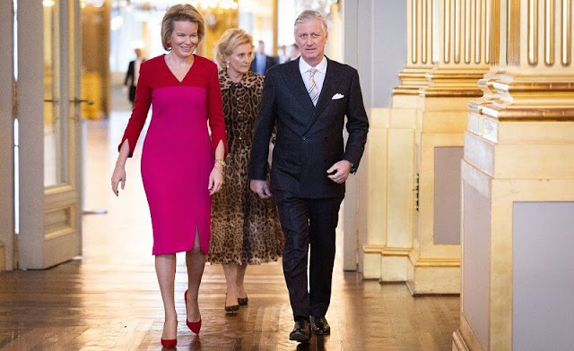 Queen Mathilde wore a fuchsia and red two tone midi silk dress by Natan. Princess Astrid wore a leopard pattern silk midi dress
