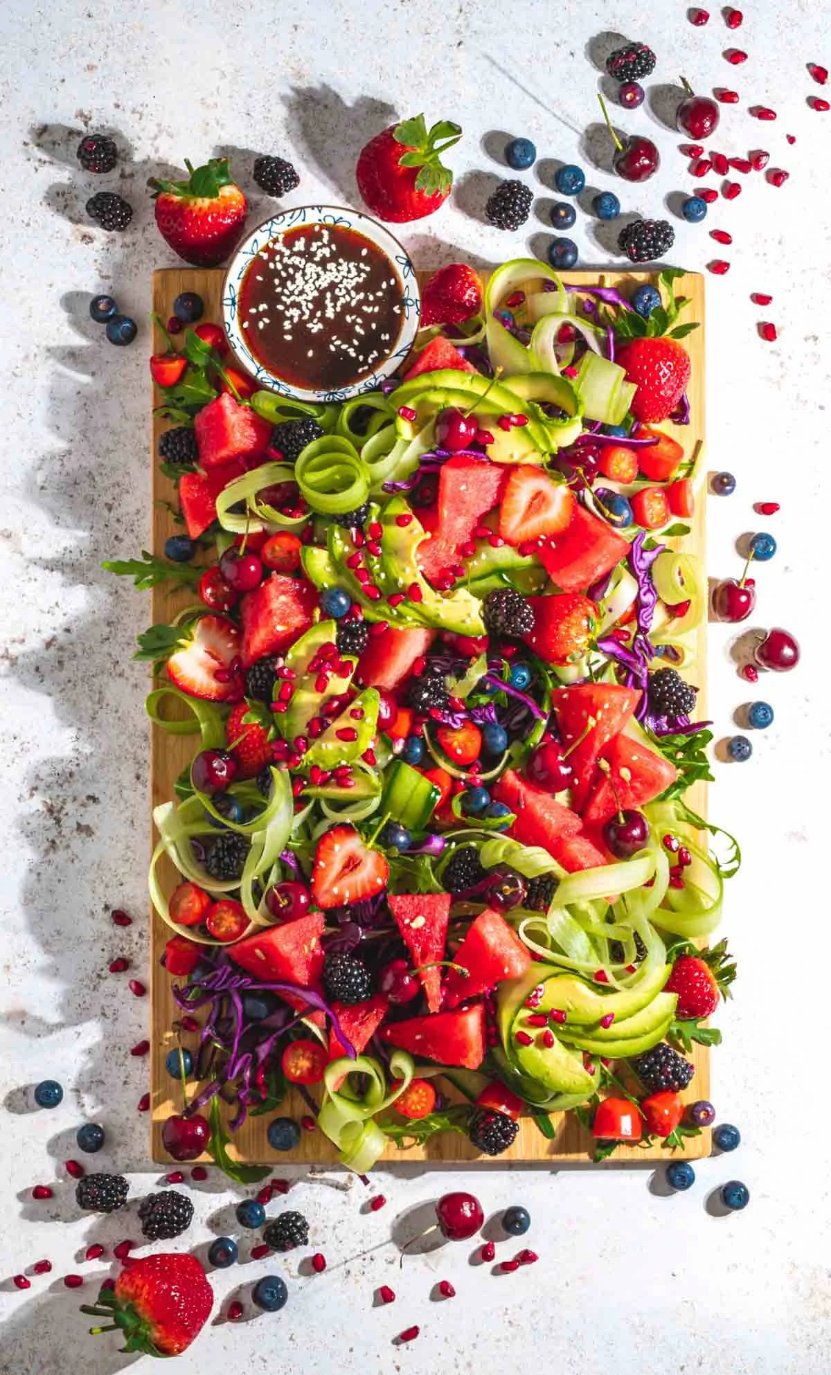 A down shot of Rainbow Salad with Chinese Vinaigrette on a wooden board.