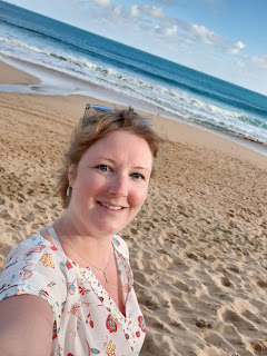  Me (Jenn) standing in the soft pale sand with the blue ocean in the background