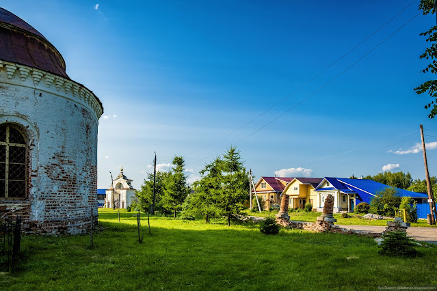 Зеленая лужайка у старой кирпичной церкви