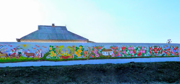 Петріківка. Центр народного мистецтва «Петріківка». Розписаний паркан на трасі Р-52