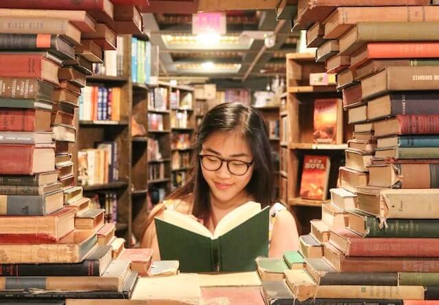 Woman reading a book inside a circle of books