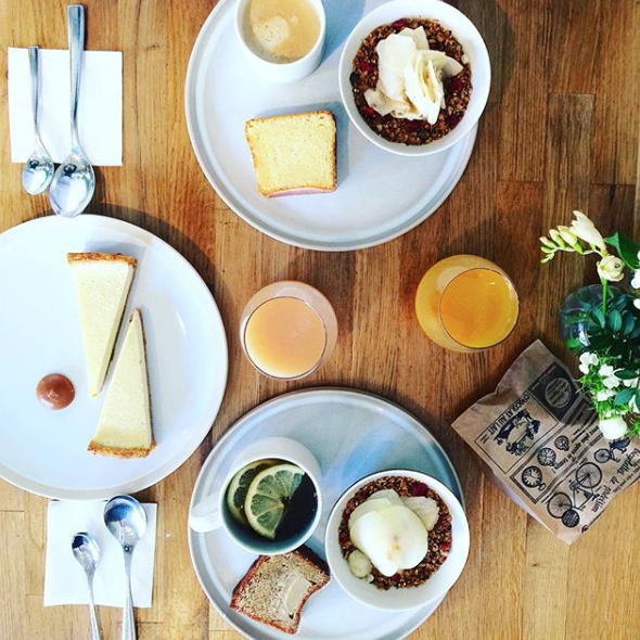 Two bowls of granola, pieces of cake and glasses of juice inside le kitchen, a great restaurant in Lyon, France