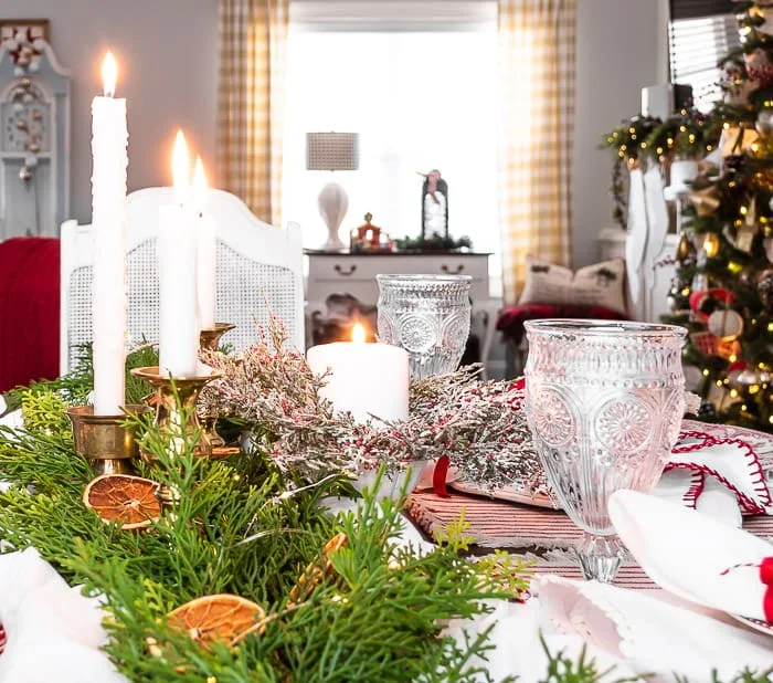 Christmas dining table cedar garland, dried orange slices, brass candlesticks