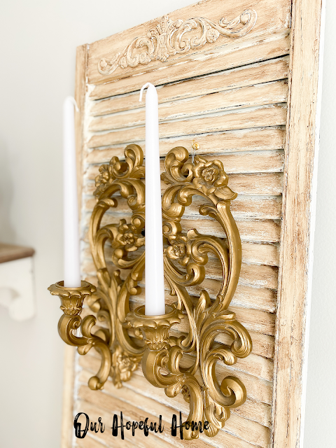gilded MCM candle sconces with white taper candles