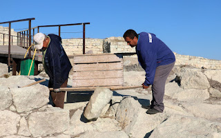 Workmen shifting stones the old fashioned way